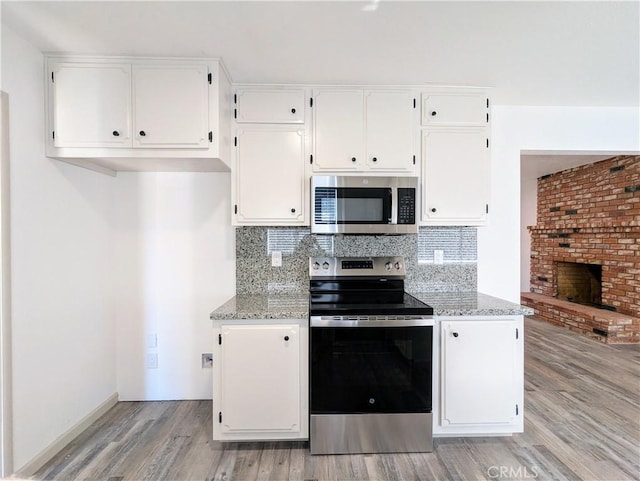 kitchen featuring white cabinetry, stainless steel appliances, and backsplash