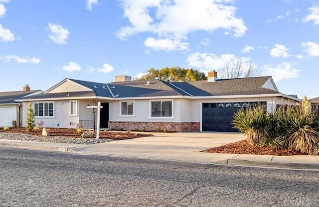 ranch-style home with concrete driveway, an attached garage, brick siding, and a chimney