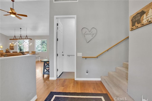 entryway with visible vents, stairway, a ceiling fan, and wood finished floors