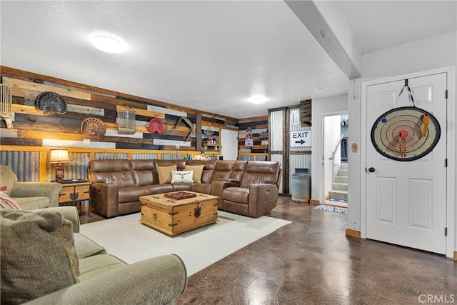 living area featuring concrete flooring and stairs