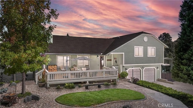 split level home featuring an attached garage, a shingled roof, and driveway