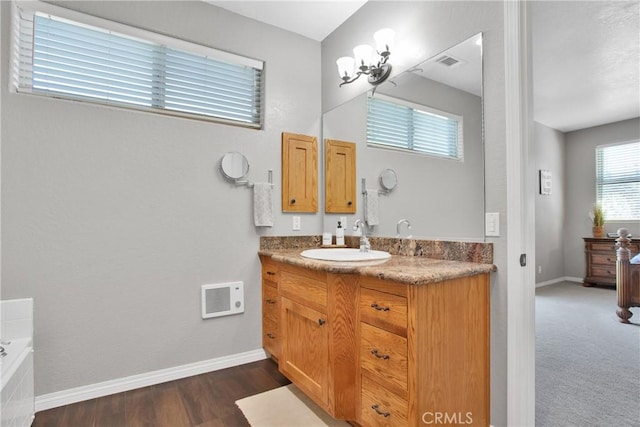 full bathroom with a bathtub, visible vents, vanity, and baseboards