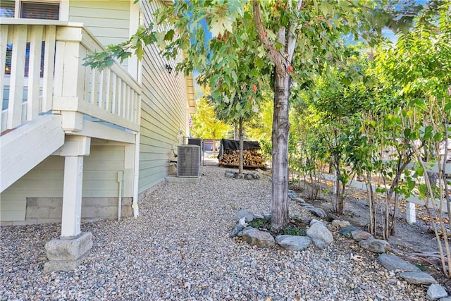 view of yard featuring central AC and fence
