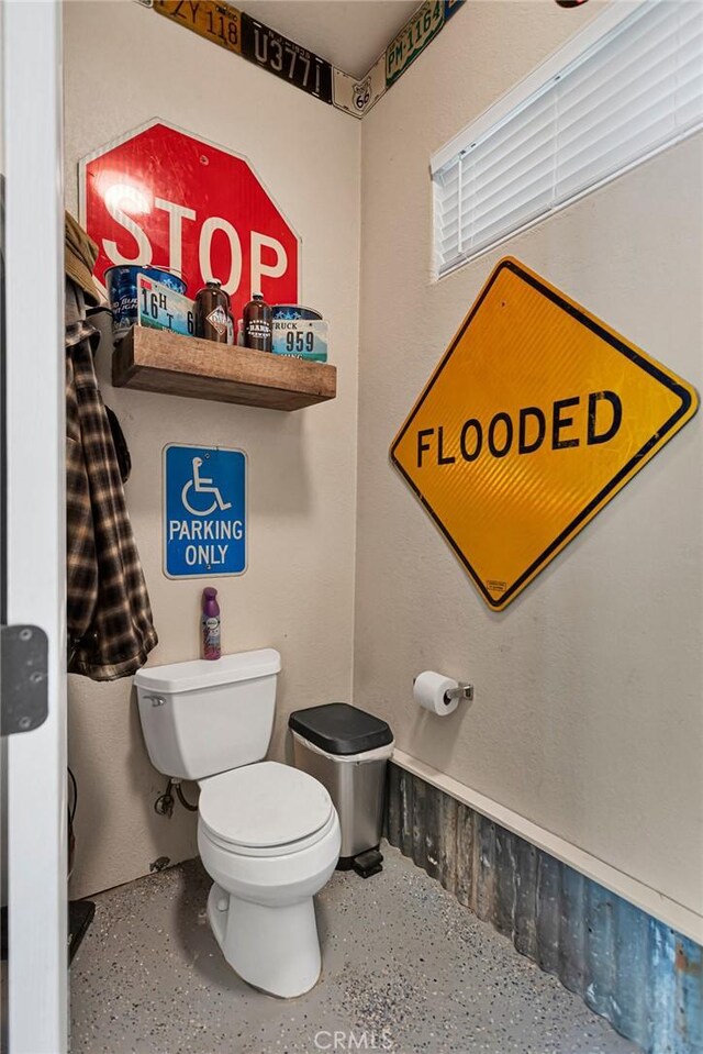 bathroom featuring toilet and speckled floor