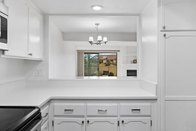 kitchen with a notable chandelier, light countertops, and white cabinets