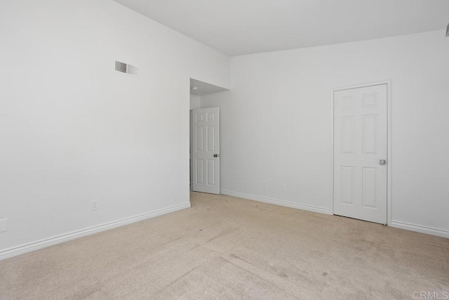 carpeted empty room featuring visible vents and baseboards