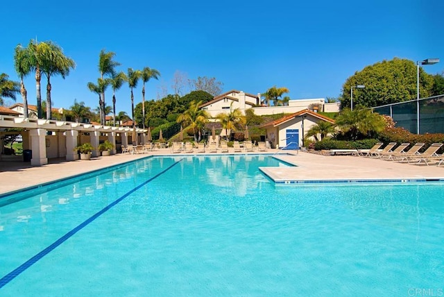 community pool featuring a patio area and fence