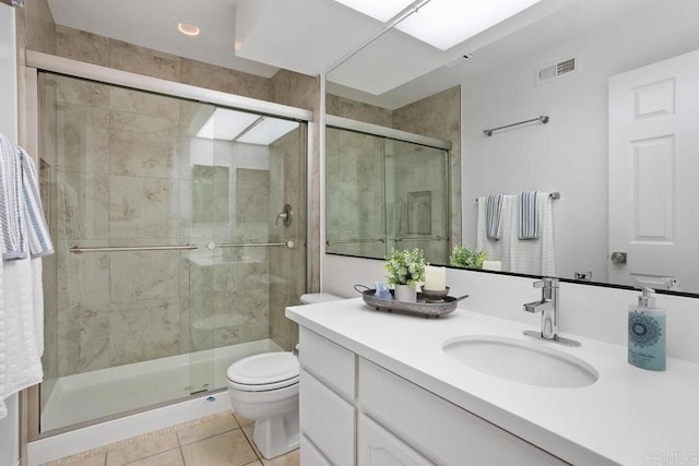 full bathroom featuring visible vents, toilet, vanity, a shower stall, and tile patterned floors