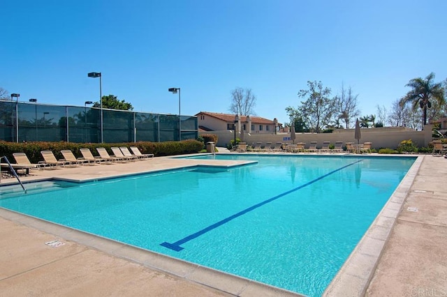 pool featuring fence and a patio