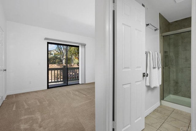 full bathroom with a shower stall and baseboards