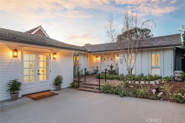 view of exterior entry featuring board and batten siding and french doors