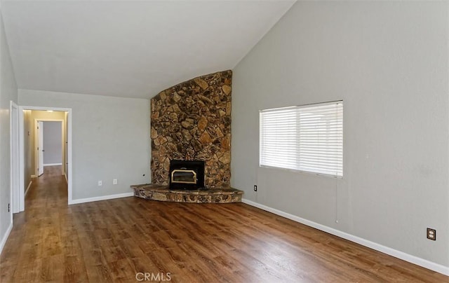 unfurnished living room with wood finished floors, baseboards, and high vaulted ceiling