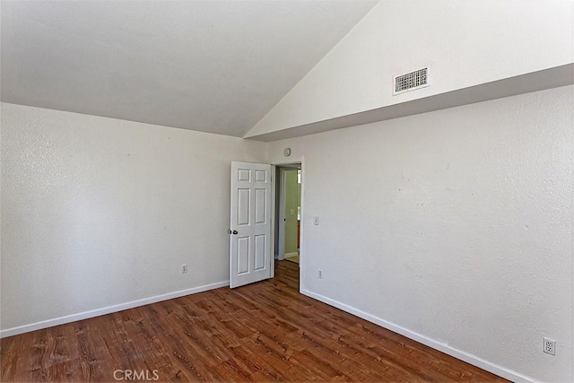 spare room with visible vents, high vaulted ceiling, baseboards, and wood finished floors