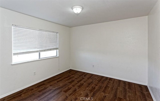 unfurnished room featuring baseboards and wood finished floors