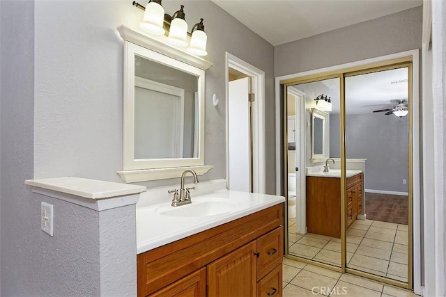 bathroom with a sink, two vanities, ceiling fan, and tile patterned floors