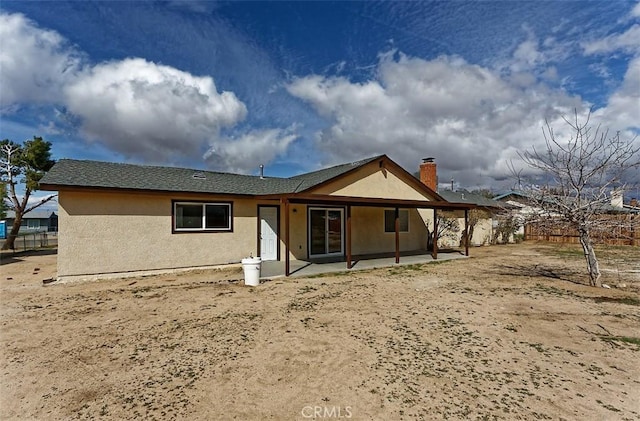 rear view of property with stucco siding and a patio