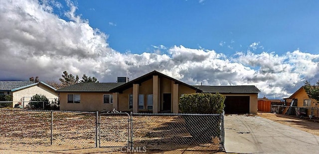 view of front facade featuring fence, stucco siding, driveway, an attached garage, and a gate