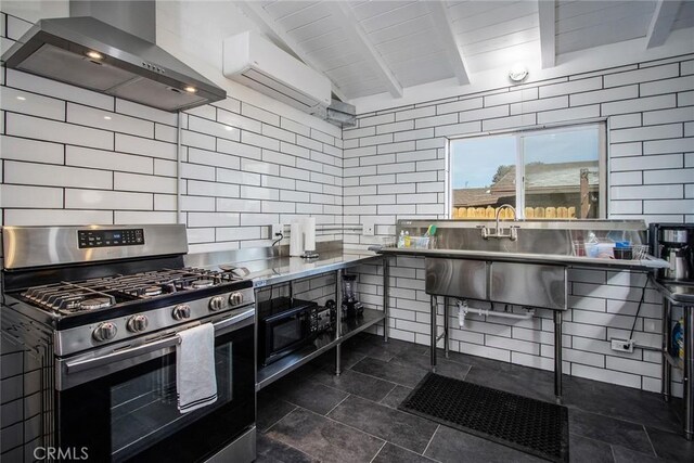 kitchen featuring a wall unit AC, wall chimney range hood, backsplash, beam ceiling, and gas stove