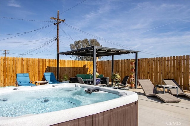 view of patio / terrace with a hot tub and fence