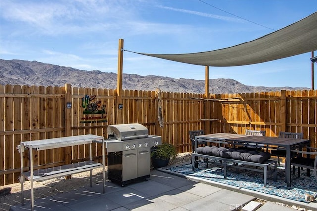 view of patio / terrace with fence, grilling area, and a mountain view