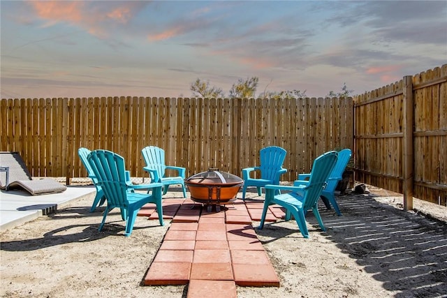 patio terrace at dusk with an outdoor fire pit and fence