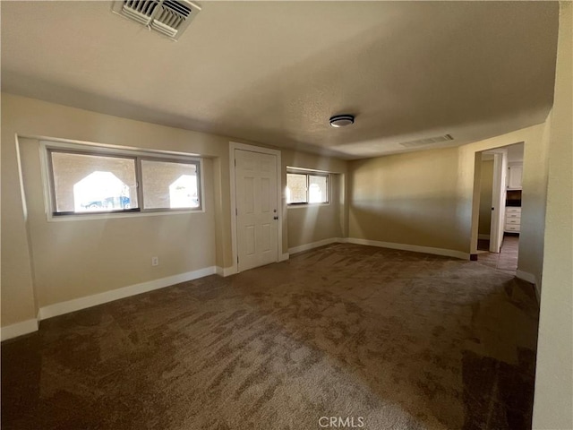 foyer with visible vents, carpet flooring, and baseboards