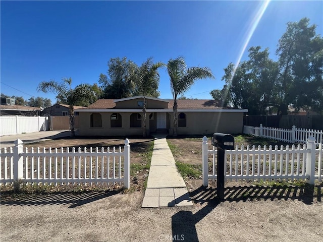 view of front of house featuring a fenced front yard and stucco siding