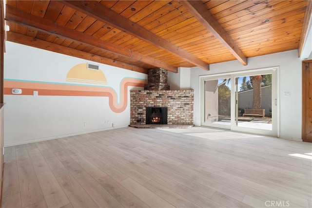 unfurnished living room featuring beam ceiling, visible vents, wood ceiling, a brick fireplace, and wood finished floors