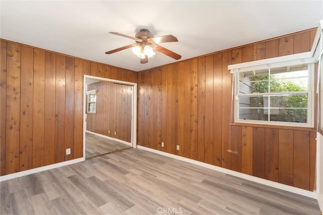 unfurnished room featuring ceiling fan, baseboards, and wood finished floors