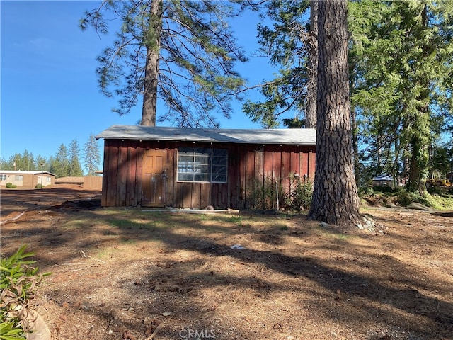 view of side of property featuring board and batten siding and an outdoor structure