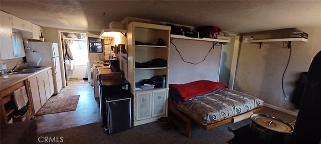 bedroom featuring freestanding refrigerator and a sink