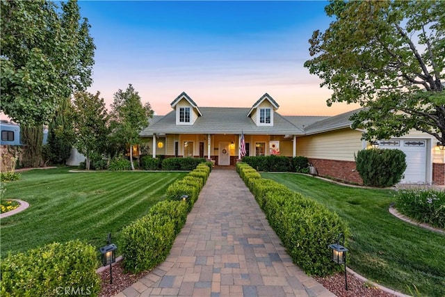 view of front of home with brick siding, an attached garage, and a front yard