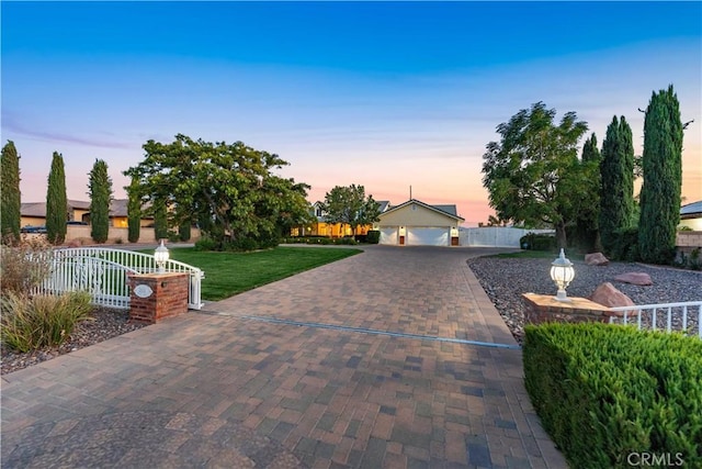 view of front of property with a garage, fence, a front lawn, and decorative driveway