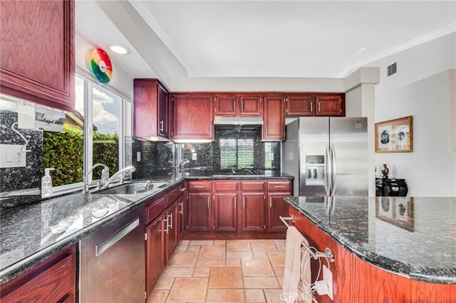 kitchen with under cabinet range hood, visible vents, stainless steel appliances, and reddish brown cabinets