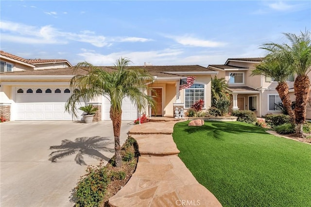 view of front of home with stucco siding, driveway, a front lawn, and an attached garage