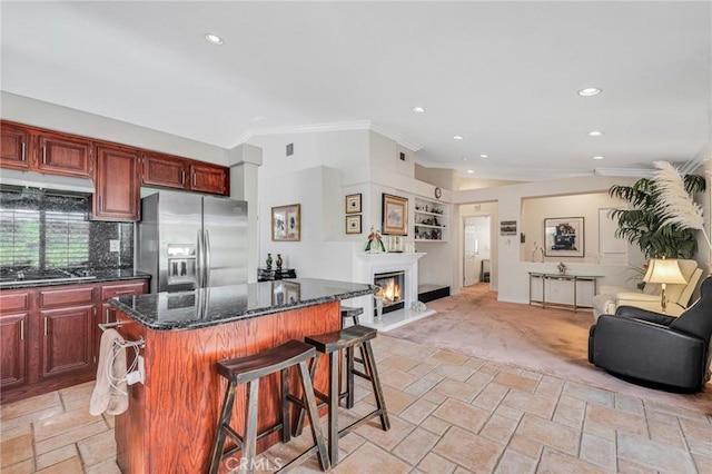 kitchen with stone tile floors, open floor plan, appliances with stainless steel finishes, and a center island
