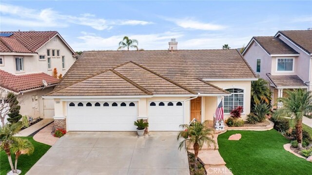 view of front of property with a garage, concrete driveway, a chimney, and a tiled roof