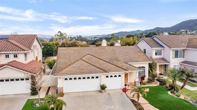 traditional home featuring a tiled roof, a mountain view, and driveway
