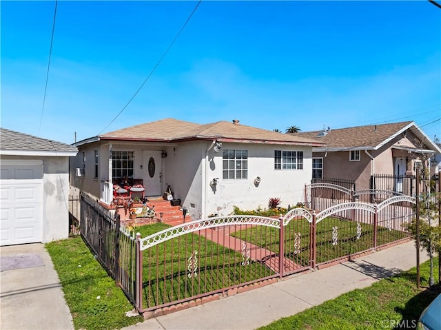 view of front of house featuring a front yard, driveway, a fenced front yard, and stucco siding