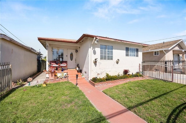 bungalow-style home with a front lawn, fence, and stucco siding