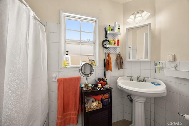 bathroom featuring curtained shower and tile walls