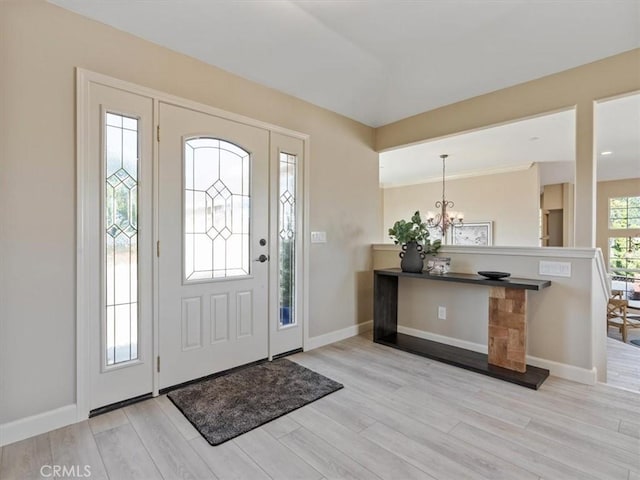 foyer featuring light wood-style floors, baseboards, and an inviting chandelier