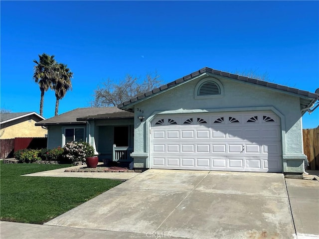 single story home with concrete driveway, a tiled roof, an attached garage, fence, and stucco siding