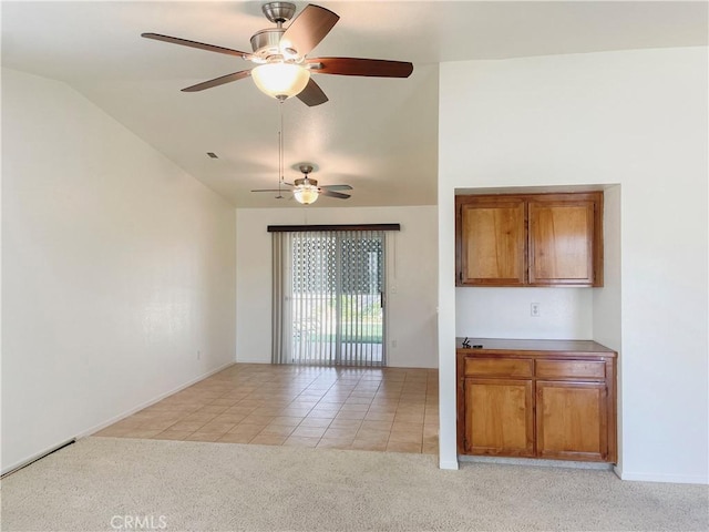 interior space featuring light tile patterned floors, vaulted ceiling, and light colored carpet