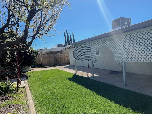 view of yard with fence, a patio, and central AC unit