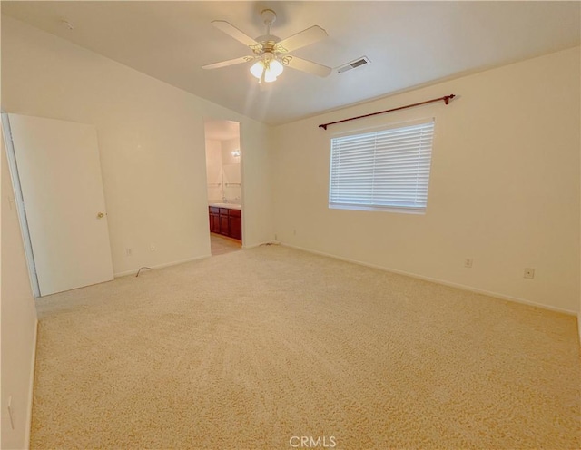 spare room featuring light colored carpet, visible vents, and ceiling fan