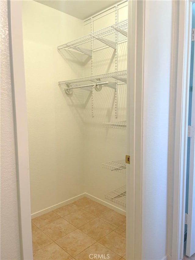 spacious closet with light tile patterned floors