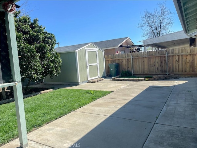 view of yard featuring a storage shed, fence, a patio, and an outbuilding