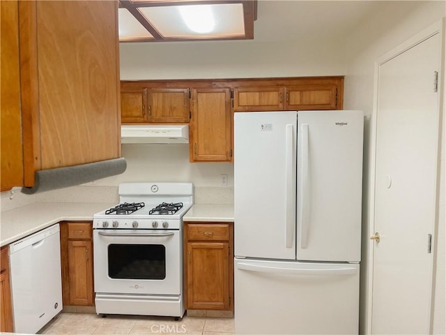 kitchen featuring white appliances, light tile patterned floors, brown cabinetry, extractor fan, and light countertops