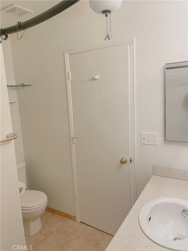 bathroom featuring toilet, vanity, tile patterned flooring, and visible vents